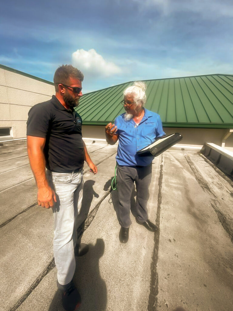 Clarity Roofing team consultation and roof assessment with client on a South Florida rooftop